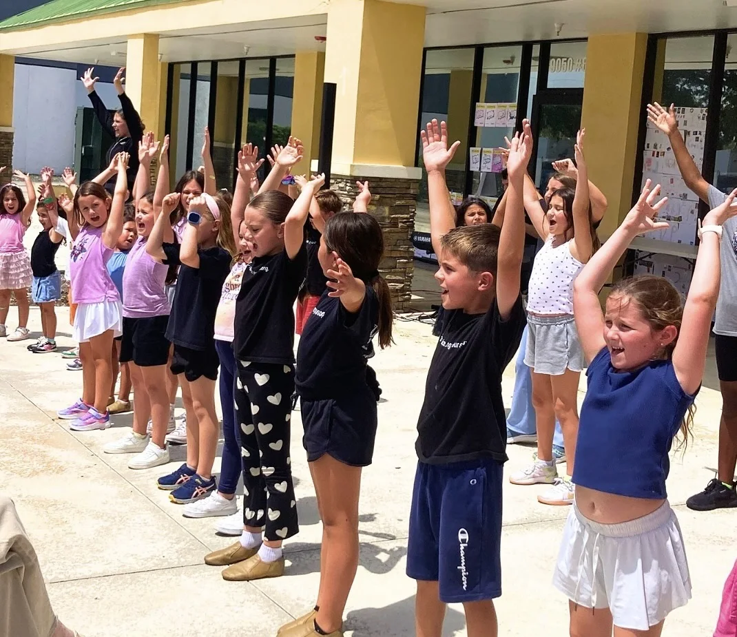 Young participants celebrating together outside the Arts and Wellness Center