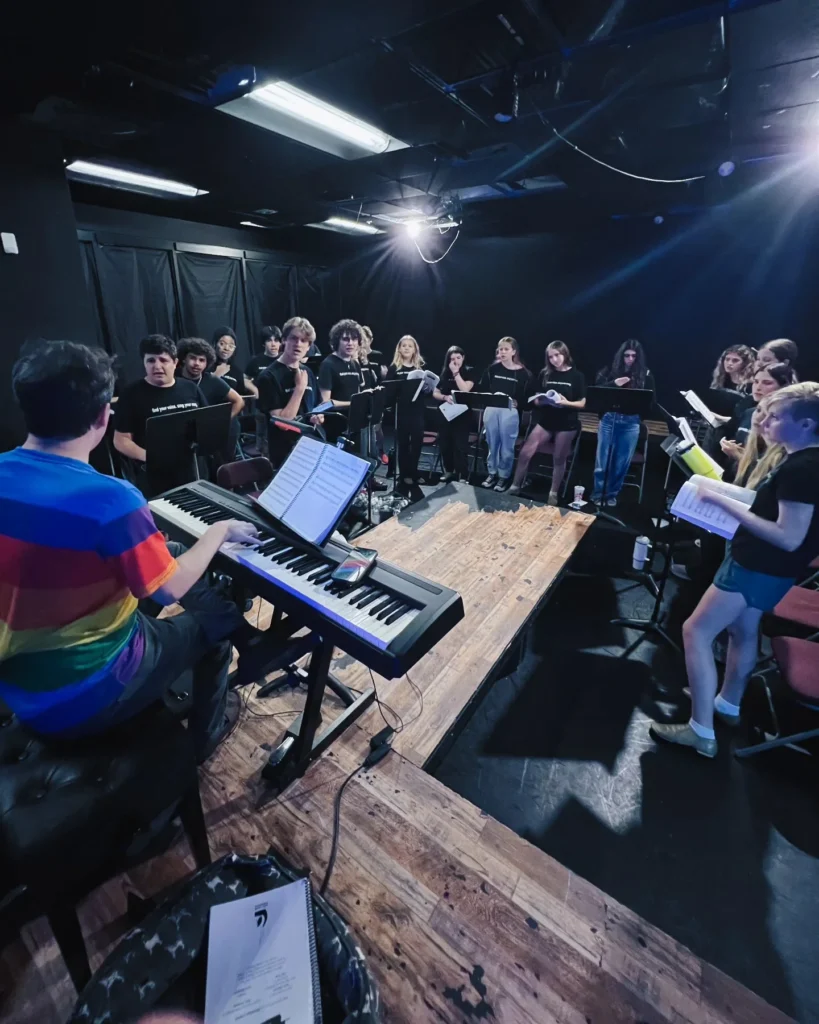 Performers rehearsing with a pianist inside the JB Black Box theatre