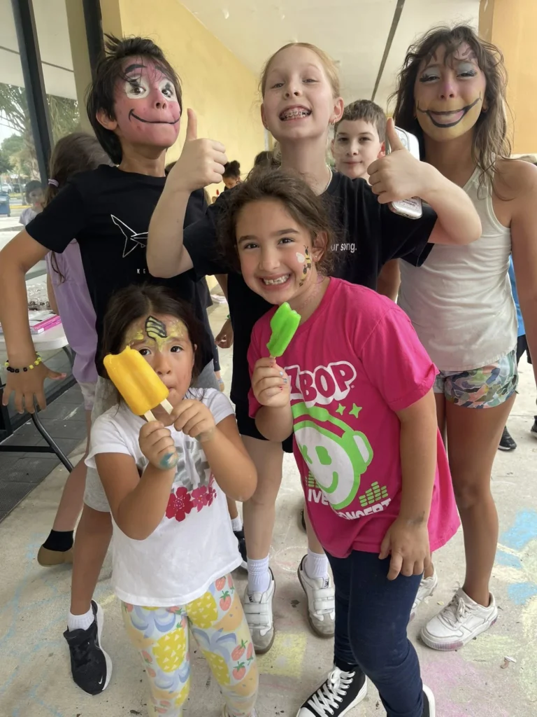Young arts program participants smiling together after a creative activity